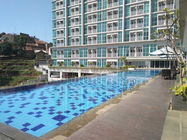 Relax by the pool surrounded by a spacious deck with a checkered floor.