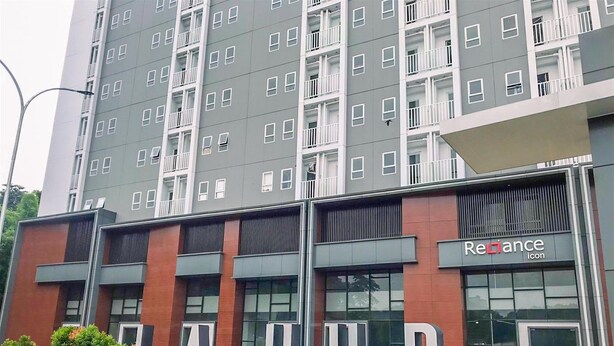 A multi-story building with a prominent 'Reliance' sign on the ground floor, suggesting a commercial space. - Nice And Cozy Studio At La Hub City Apartment (Jakarta)