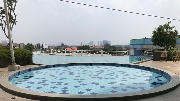 A circular pool with blue tiles, surrounded by a tiled deck. - Best Deal 2Br Apartment At Cinere Bellevue Suites (Depok)