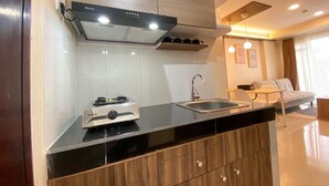 A modern kitchen with a built-in stove, a sink, and a wooden cabinet.