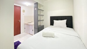 Ein Hotelzimmer mit Bett, Badezimmer und Küchenzeile.