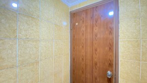 Ein Badezimmer mit gelben Fliesen und einer Holztür.