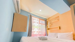 A hotel room with a bed, a wardrobe, and a window with curtains. - Homey Living 2Br At Jarrdin Cihampelas Apartment (Bandung)
