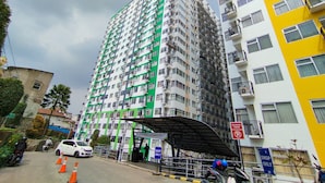 A multi-story residential building with balconies and a gated entrance. - Homey Living 2Br At Jarrdin Cihampelas Apartment (Bandung)