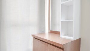 Ein Teil des Raumes mit einem Holzschrank und einem weißen Regal.