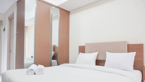 Ein Hotelzimmer mit einem großen Bett, einem hölzernen Kopfteil und einem Schrank mit Spiegel.