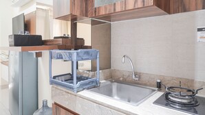 Eine moderne Küche mit Spülbecken aus Edelstahl, einem Gasherd und Holzschränken.