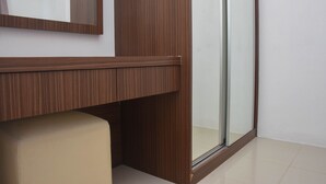 A bathroom with a wooden vanity, a mirror, and a glass shower enclosure.