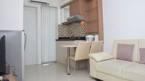 A compact kitchen with a dining area and a sofa.
