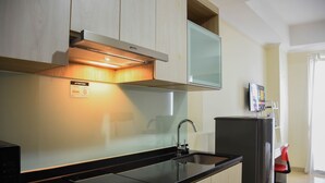 Eine moderne Küche mit eingebauter Mikrowelle, einer Edelstahl-Dunstabzugshaube und einer schwarzen Arbeitsplatte.