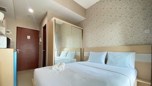 A hotel room with a large bed, a wardrobe, a mirror, and a door. - Well Designed Studio Apartment At Taman Melati Jatinangor (Hegarmanah)