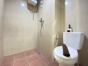 A bathroom with a toilet, a shower, and a wall-mounted water heater. - Cozy Studio Corner Room At Taman Melati Jatinangor Apartment (Hegarmanah)