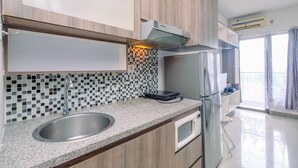 A modern kitchen with a stainless steel sink, a microwave, and a built-in oven.