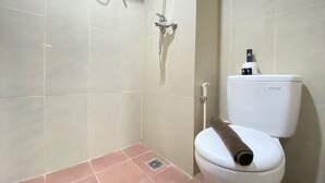 Une salle de bain comprenant des toilettes, une douche et un bidet.