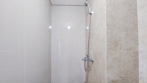 A shower with a handheld showerhead and a wall-mounted faucet. - Nice And Modern Studio At Transpark Bintaro Apartment (South Tangerang)