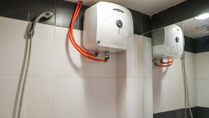 Des toilettes équipées d’un sèche-mains, d’un miroir et d’une pomme de douche.