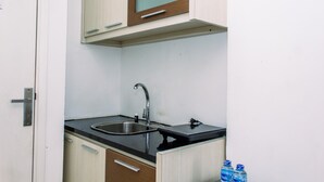 A compact kitchen with a sink, cabinets, and a countertop. - Comfort Stay Studio Room At Poris 88 Apartment (Tangerang)