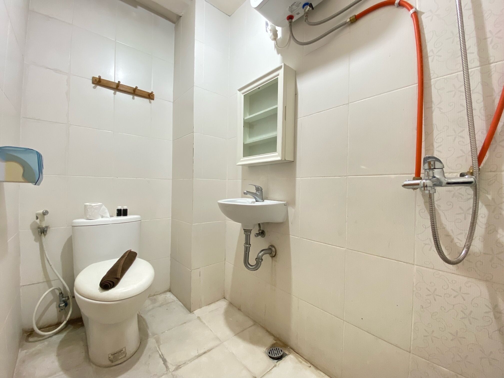 A small bathroom with a toilet, sink, and shower.