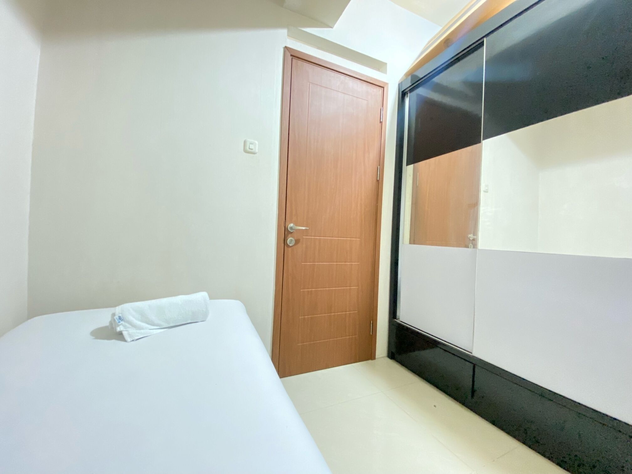 Une chambre à coucher avec un lit, une porte en bois et une armoire.