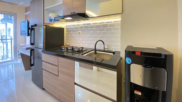 Een moderne keuken met een roestvrijstalen koelkast, een inbouwoven en een zwart aanrecht.