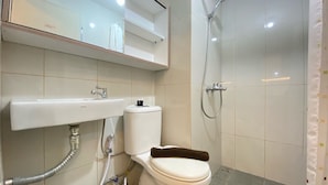 Een badkamer met toilet, wastafel, douche en spiegel.