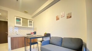 A compact living space with a kitchenette, a dining table, and a sofa. - Gorgeous 2Br Apartment At Mekarwangi Square Cibaduyut (Bandung)