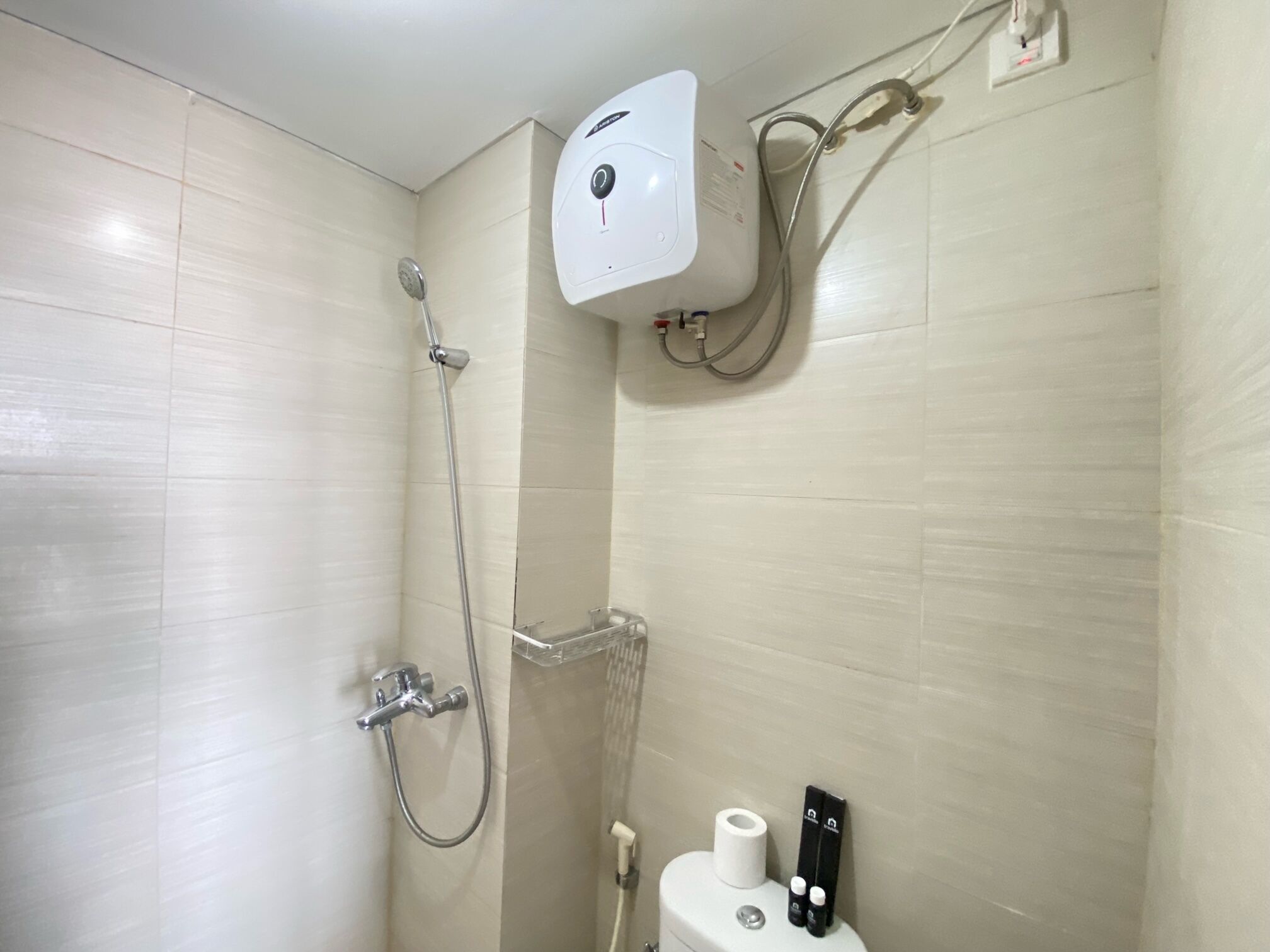 Une salle de bain équipée d’une douche, de toilettes et d’un sèche-mains.