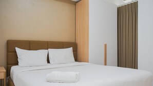 Ein ordentlich bezogenes Bett mit weißen Leinen und Kissen, ein Holzkopfteil und ein brauner Vorhang am Fenster.