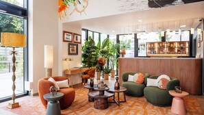 A modern lobby with seating, a reception desk, and a bar area. - Residhome Quai d'Ivry (Ivry-sur-Seine)