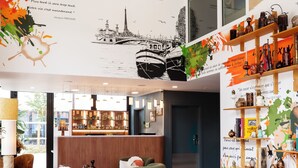 A modern interior with a green sofa, colorful rug, and a bar area. - Residhome Quai d'Ivry (Ivry-sur-Seine)