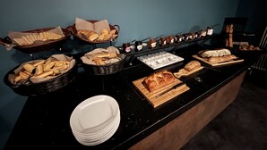 Ein Buffet mit verschiedenen Brotsorten, Gebäck und Beilagen.