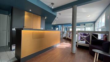 Een modern ingerichte receptie met een houten balie, blauwe wanden en een hoog plafond met ingebouwde verlichting.