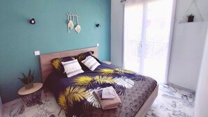A bedroom with a bed, a window, and a wall decoration.