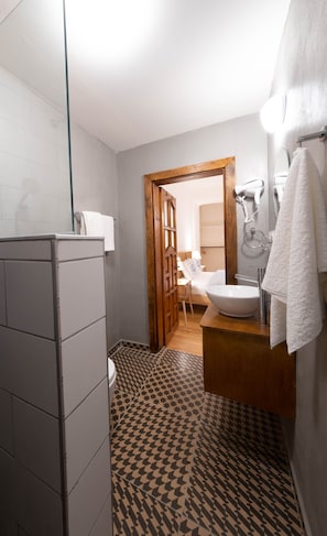 A bathroom with a shower, toilet, sink, and a patterned floor. - Penthouse in the Heart of Pera (Istanbul)