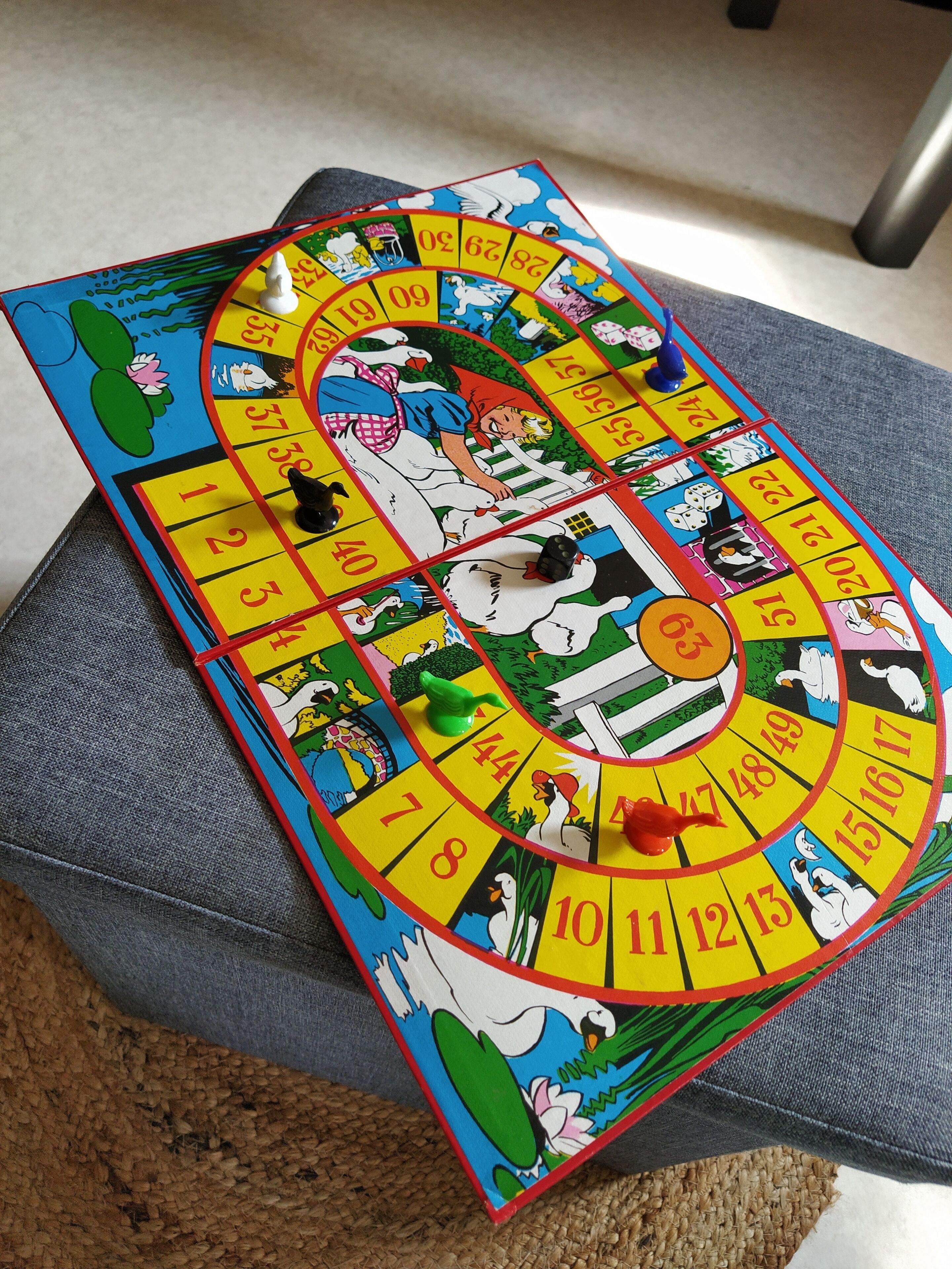 A board game with a colorful spiral track and various cartoon characters.
