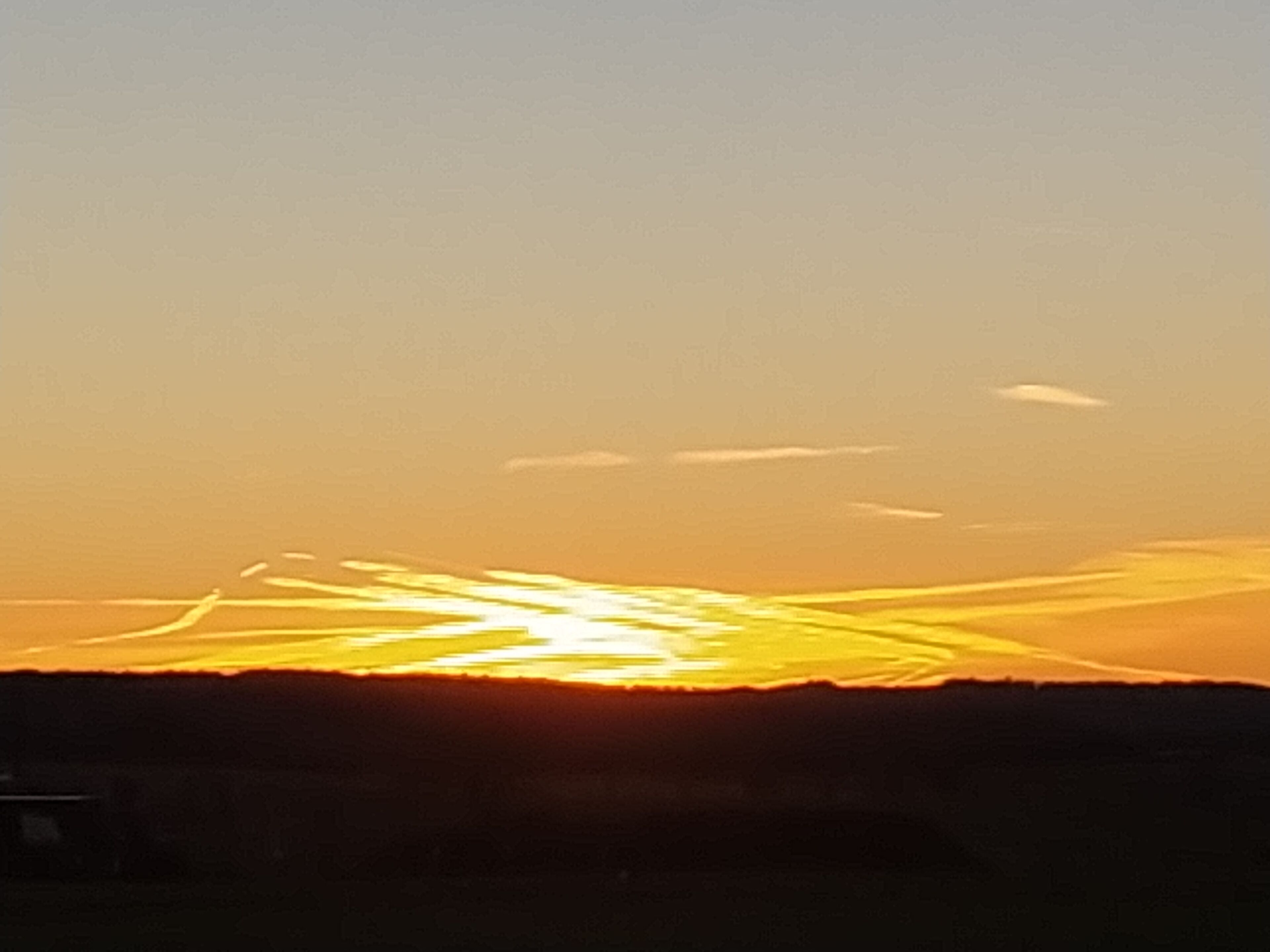 A sunset over a flat landscape with a clear sky.