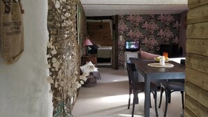 Un intérieur rustique comprenant un coin repas, un téléviseur et une cheminée.