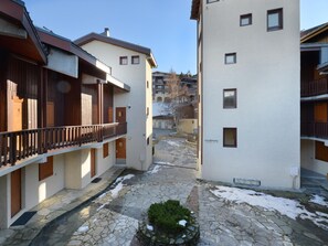 Eine enge Straße mit Gebäuden an beiden Seiten, mit Balkonen und Holzgeländern sowie einem gepflasterten Untergrund aus Stein.