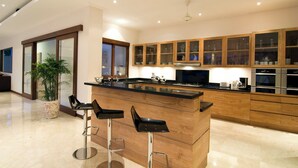 Een moderne keuken met een centraal eiland, houten kasten en een groot raam.