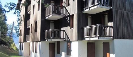 Un edificio de varios pisos con balcones y un techo inclinado.