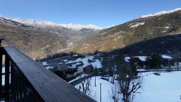 A mountain landscape with snow-covered peaks and a valley below.
