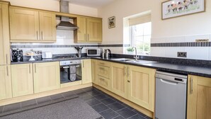 A modern kitchen with wooden cabinets, a stainless steel range, a microwave, and a dishwasher.