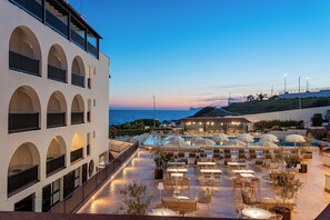 Un bar en la azotea con mesas al aire libre y vistas al mar.