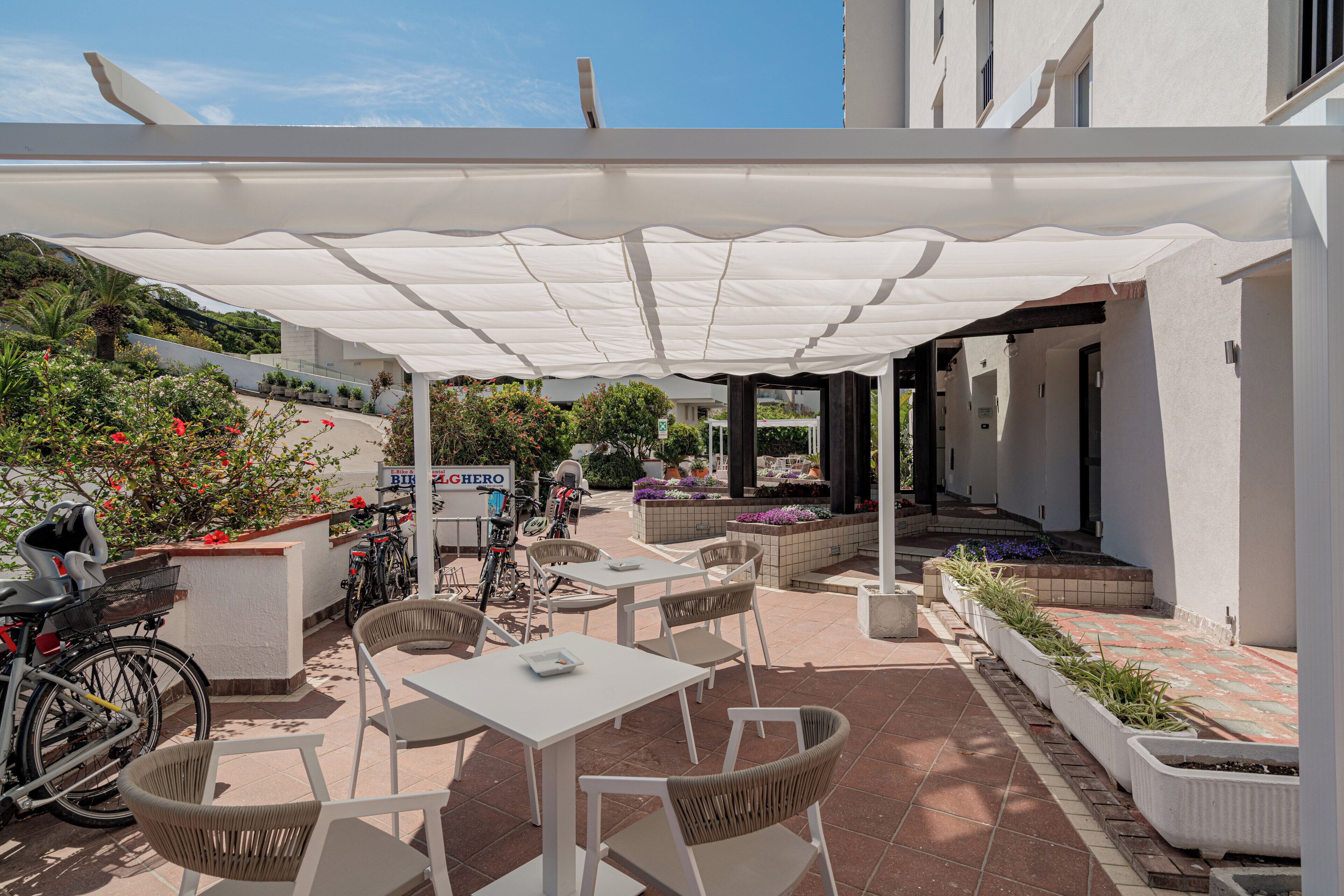 An outdoor patio area with tables and chairs, a covered seating area, and a bike rack.