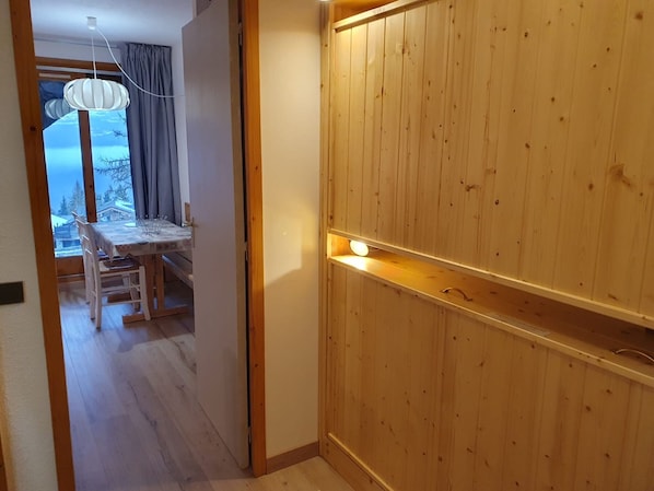 A wooden interior with a dining area and a view through a window.