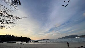 A beach with people, boats, and a clear sky. - Nanai 2 Residence Patong (Patong)
