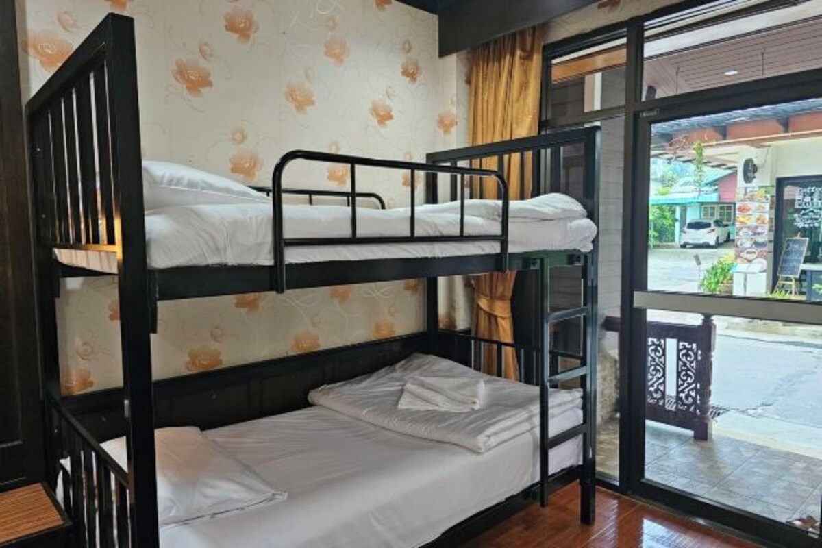 Dormitorio con literas y vista a la calle y una tienda.