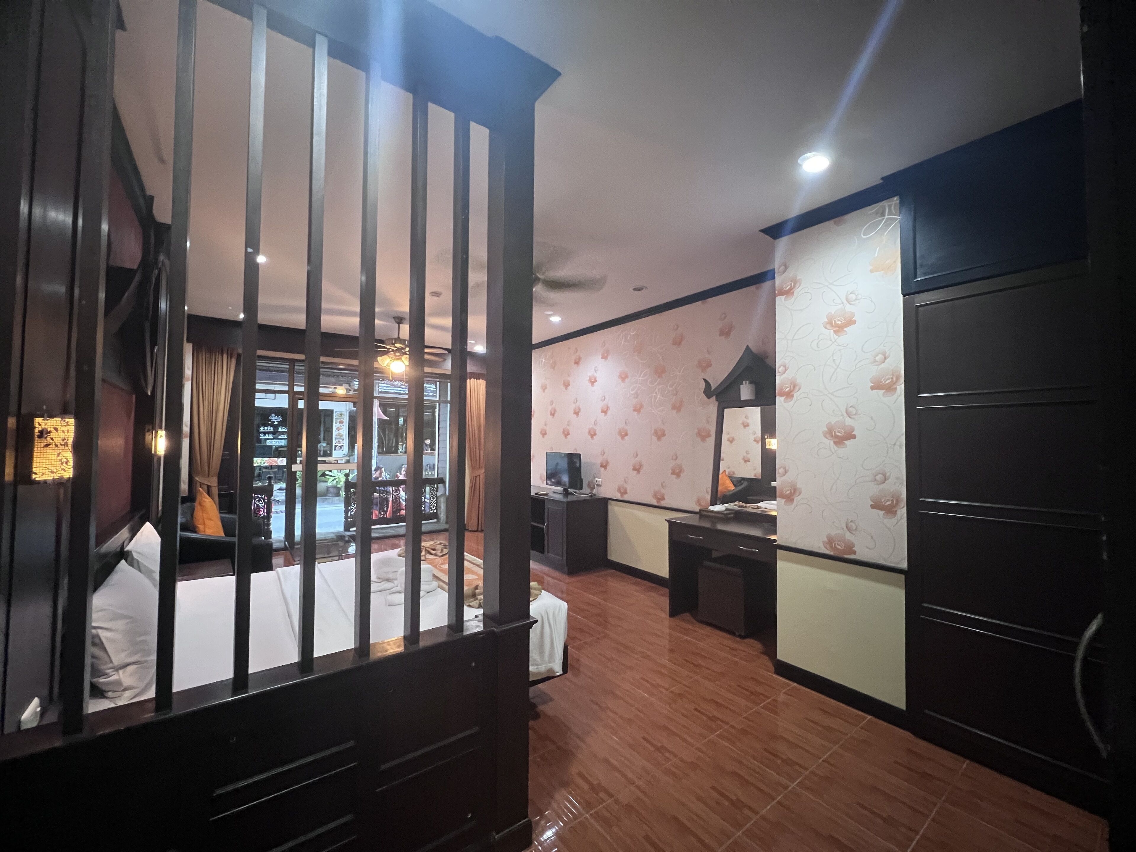 Habitación de hotel con una cama grande, un escritorio, una silla, un armario y vista a la calle.