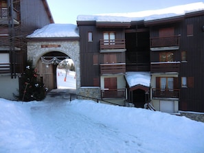 A snow-covered building with a stone archway labeled "LE CHRISTIANA."