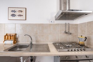 Réfrigérateur, un four, surface de cuisson, vaisselle et ustensiles